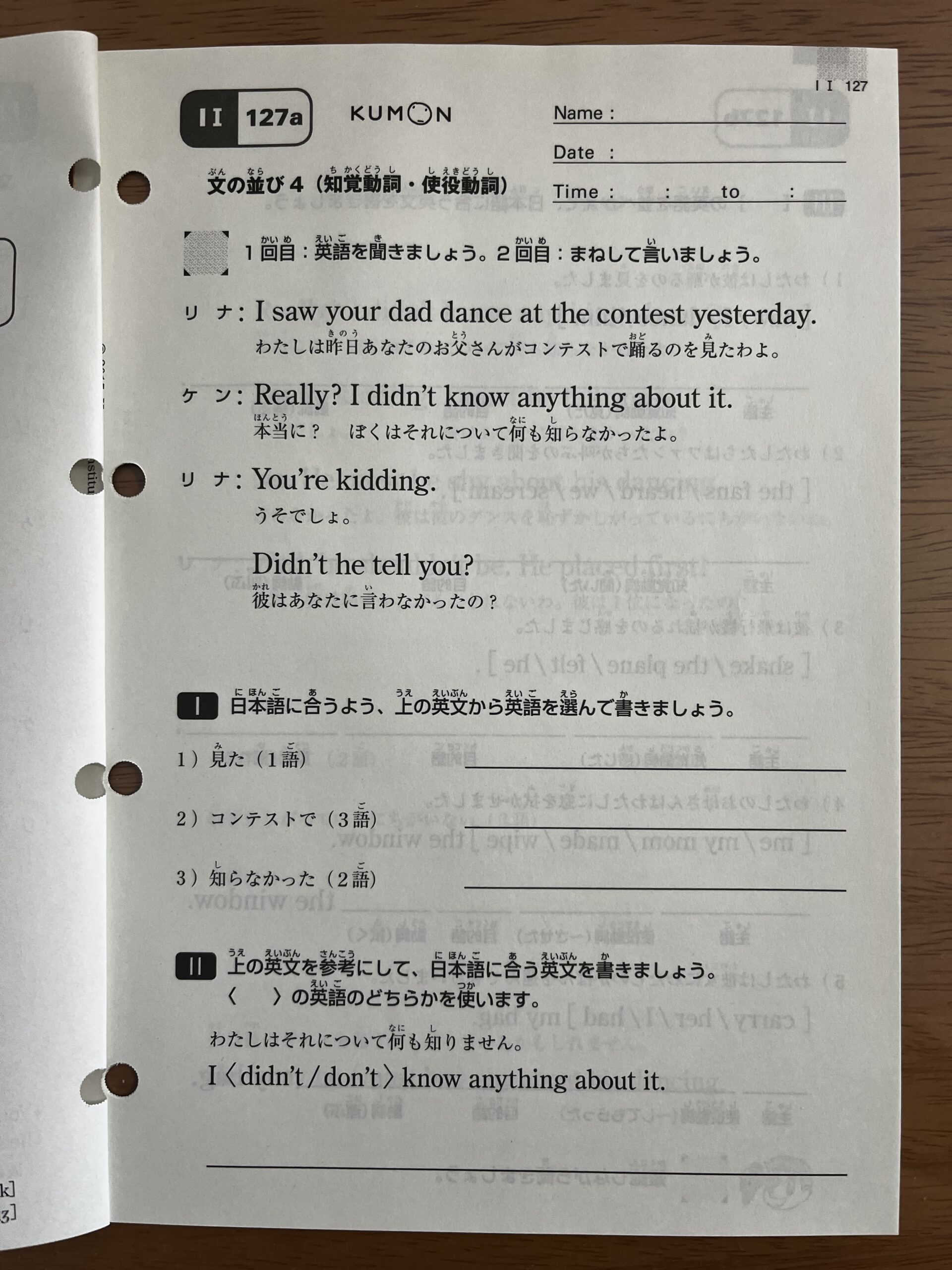 上の子の公文英語IⅠ教材のプリント127a（表）。「1回目：英語を聞きましょう。2回目：まねして言いましょう。」の指示のあとに会話文があり、その下に英語を書く問題が続きます。名前・日付の欄は空欄です。