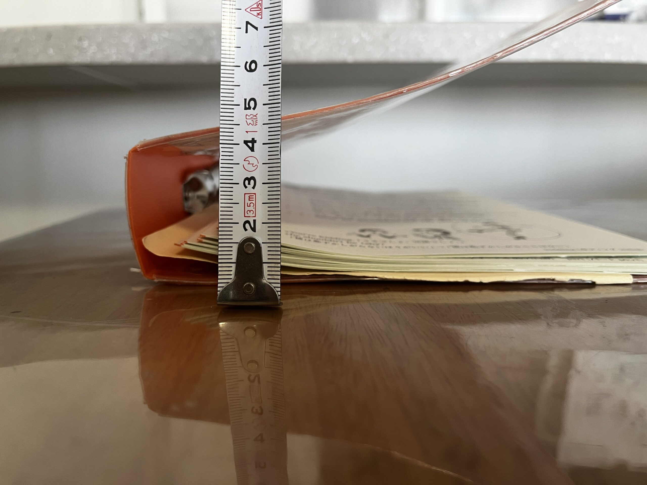 バインダーにとじたプリントの厚みを測ったところ。わが家で測ると1束で約1mm、とじてある分で約5mm